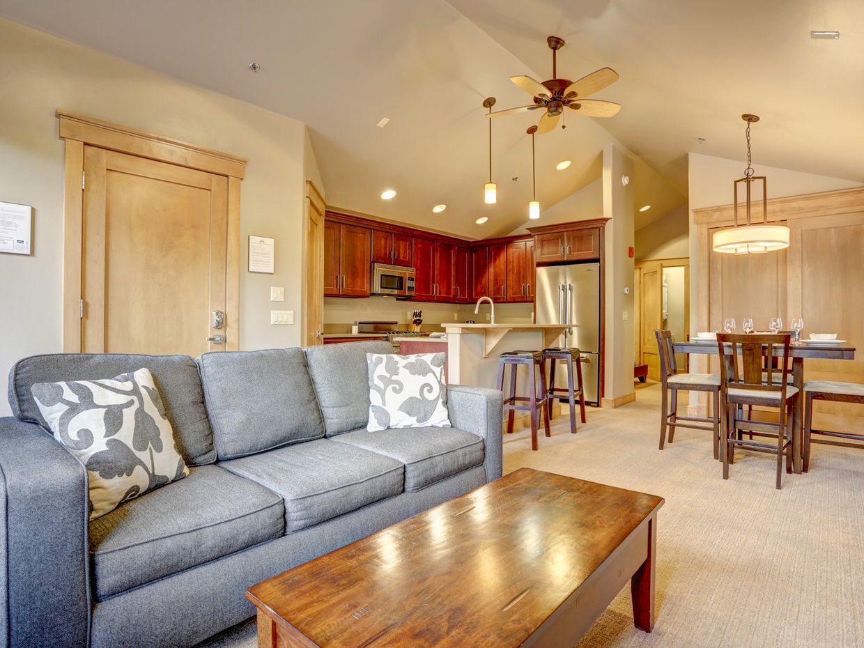 View of the main entrance behind the couch, and entryway in back leading towards bedroom area