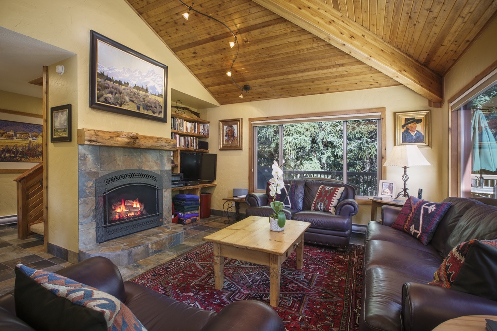 View into the living room with gas fireplace and flat screen television.
