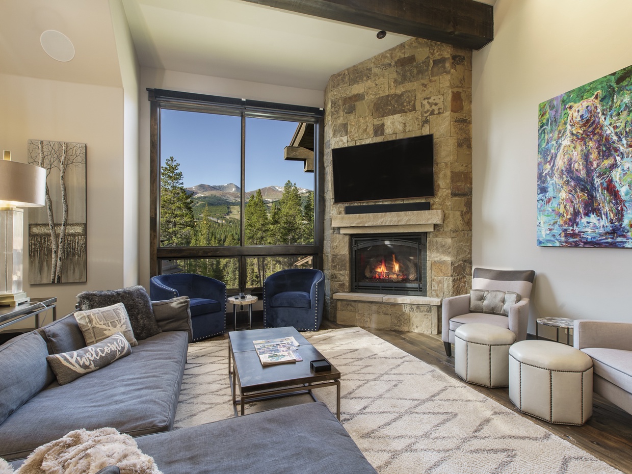 View into the living room with gas fire place, large flat screen television, and unbelievable slope side views!