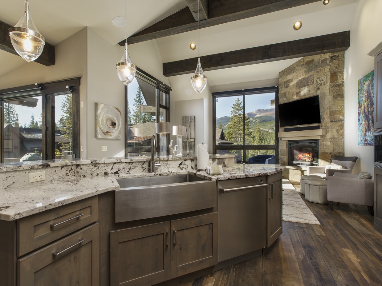 View into the kitchen with double oven, large sink, dishwasher, coffee maker, toaster oven, toaster, microwave, and refrigerator.