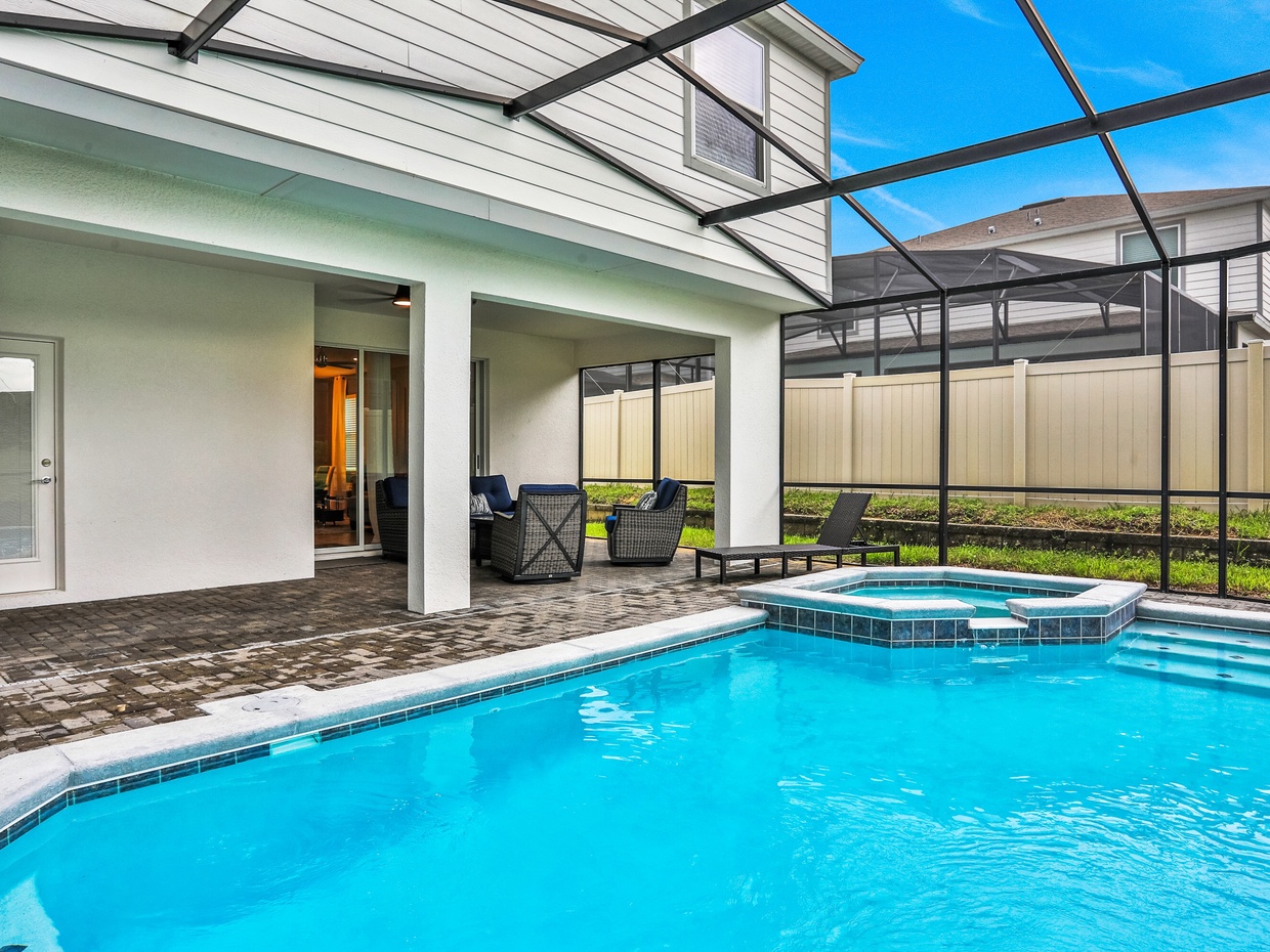 Enclosed lanai with private pool & spa, seating area and lounge chair