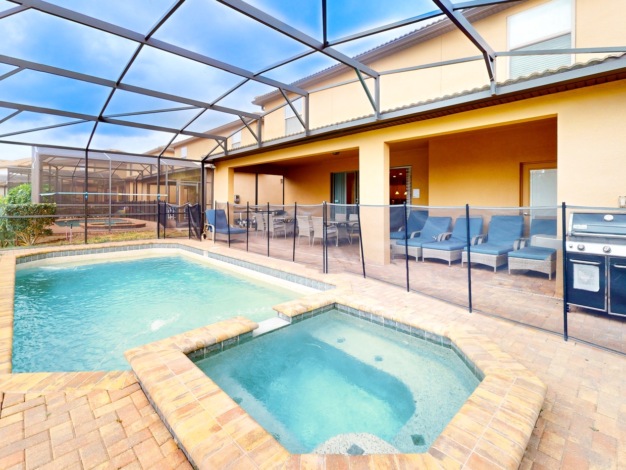 Relaxing pool and attached spa on the partially covered lanai with child safety gate.
