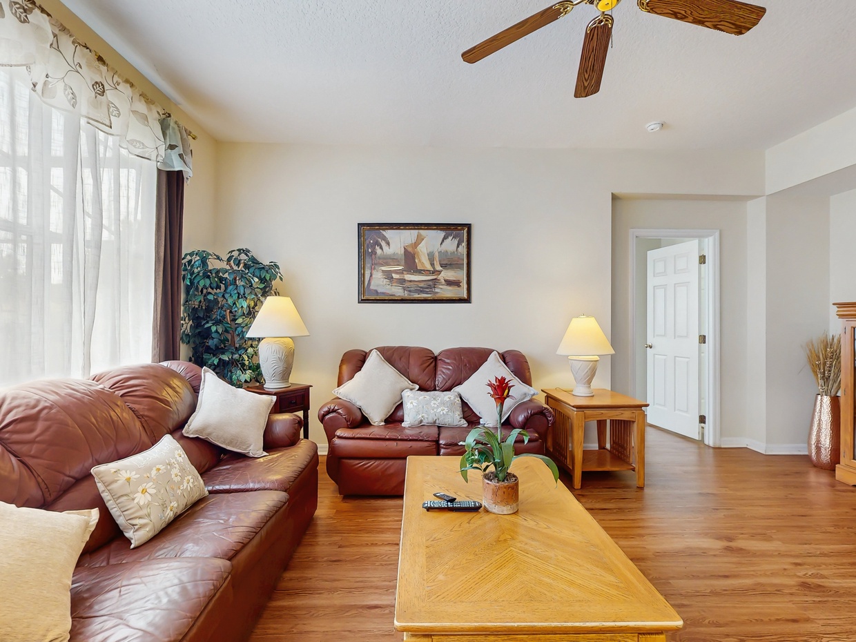 Main living room area with ceiling fan & TV