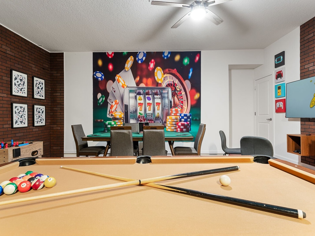 Game room with pool table, foosball table, and game consoles, perfect for family fun and entertainment