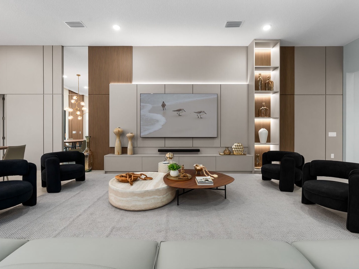 Sleek and spacious living room featuring modern furniture, ambient lighting, and a large smart TV, perfect for relaxing or hosting a movie night in style.