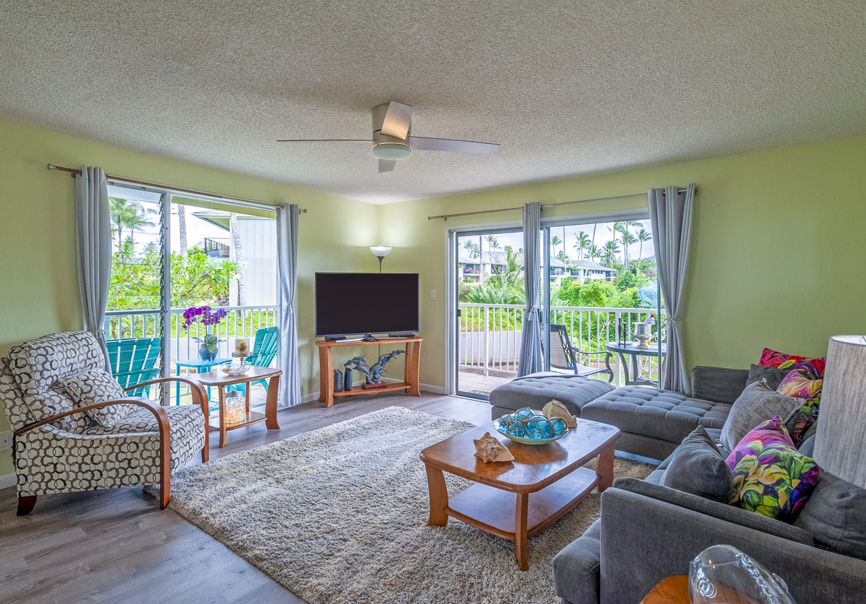 The living room is bright and cheerful thanks to the wrap-around lanai windows and charming natural wood accents. 