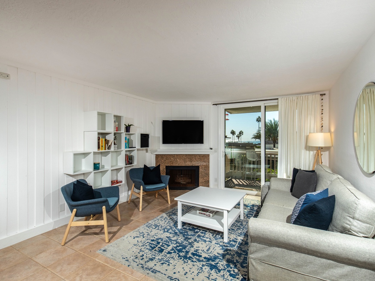 The ocean view living area has a queen sleeper, 2 chairs, and a cozy fireplace with granite surround.