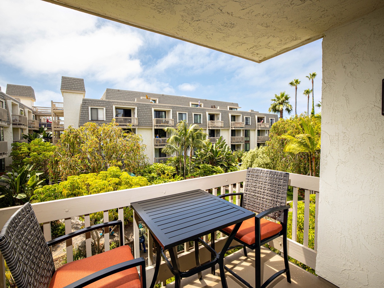 Relax on your private patio overlooking a running stream and lush greenery.