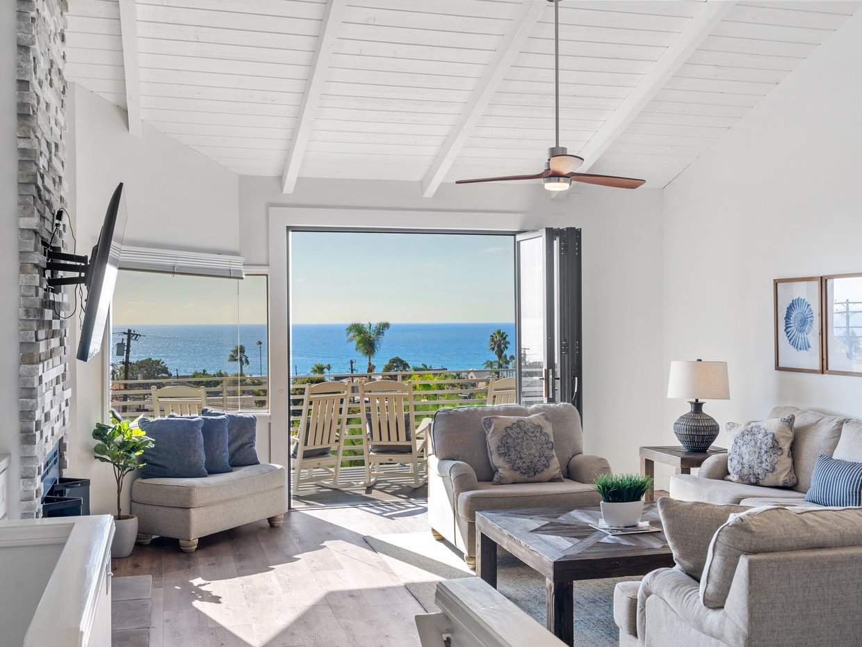 Living room with vaulted ceilings and ocean-view balcony in a Ca