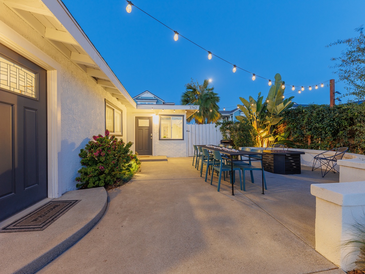 Front patio with outdoor dining table, firepit, and string light