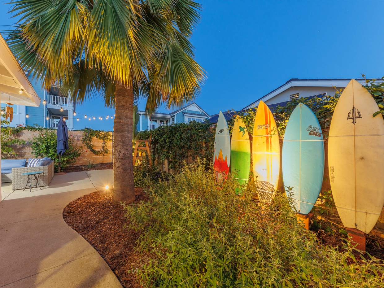 Garden pathway with surfboard wall display and tropical plants l