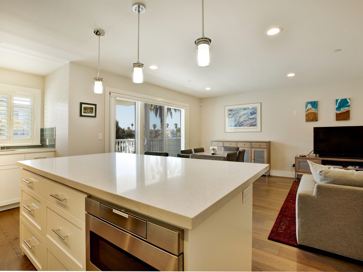 Spacious open living and kitchen area with balcony and propane BBQ just off living area.