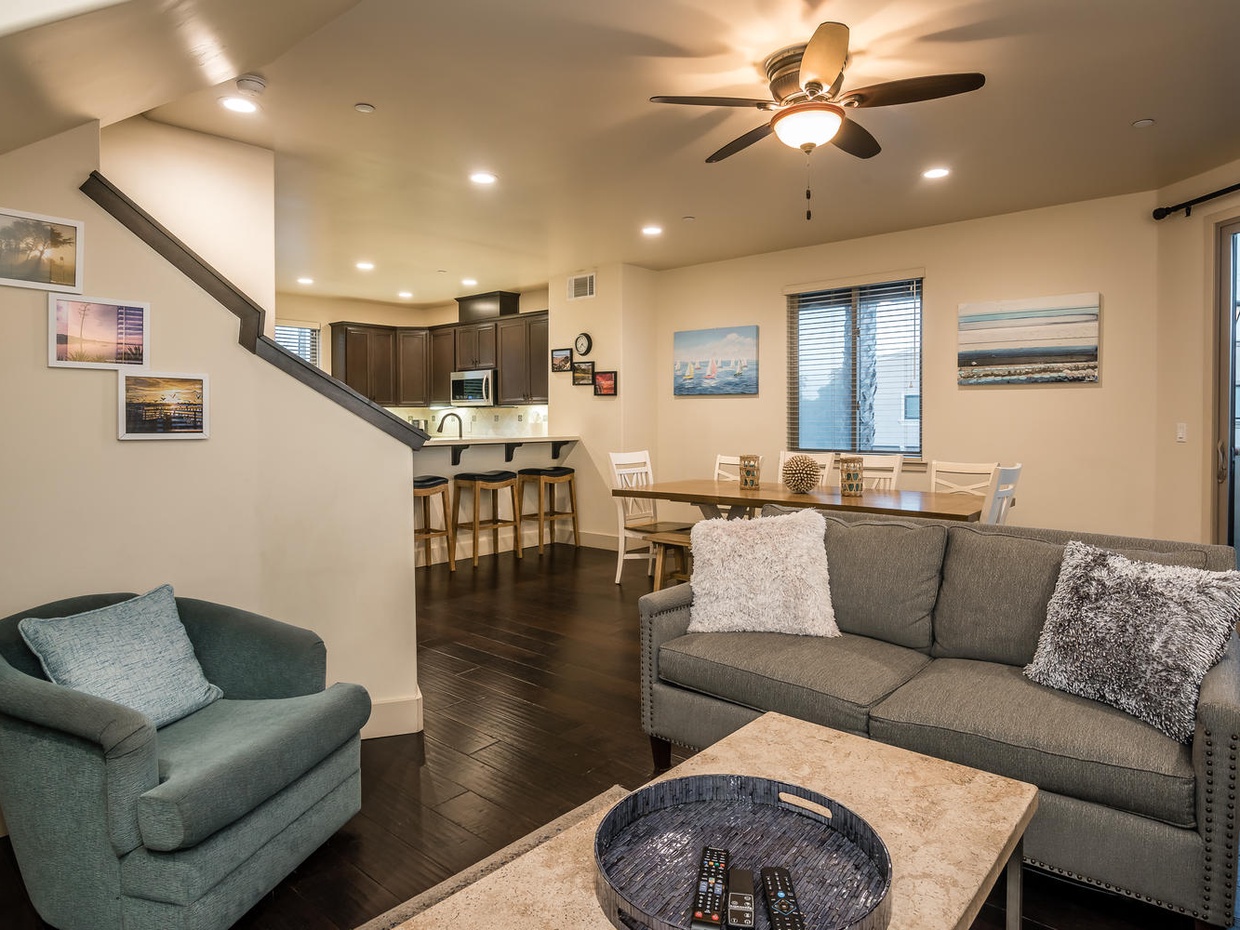 Living room, dining area and kitchen open space for friends and family to gather. Nearby is a sliding door leading to a balcony.