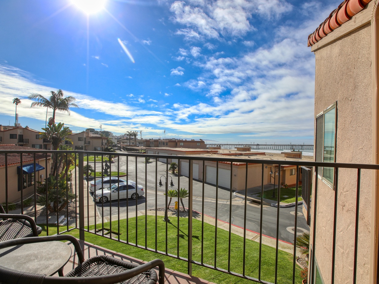Step outside to your private deck, where you can enjoy the fresh ocean breeze and a serene view of the lush, grassy lawn below.