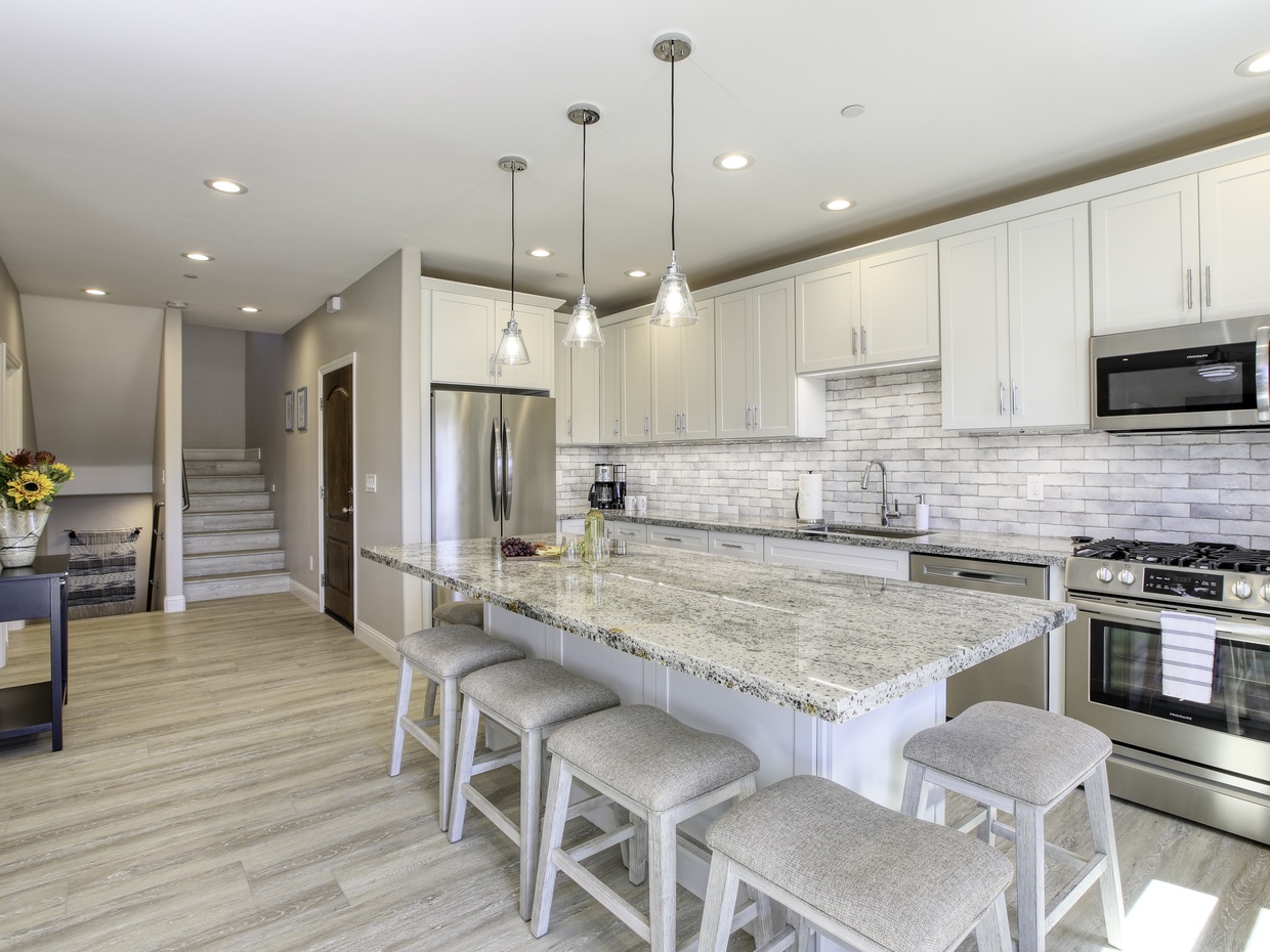 The kitchen showcases professional-grade appliances, seamlessly connecting to the living room and offering ample space for food preparation.

Dining table for 6 guests, plus bar stools at the nearby kitchen island. 