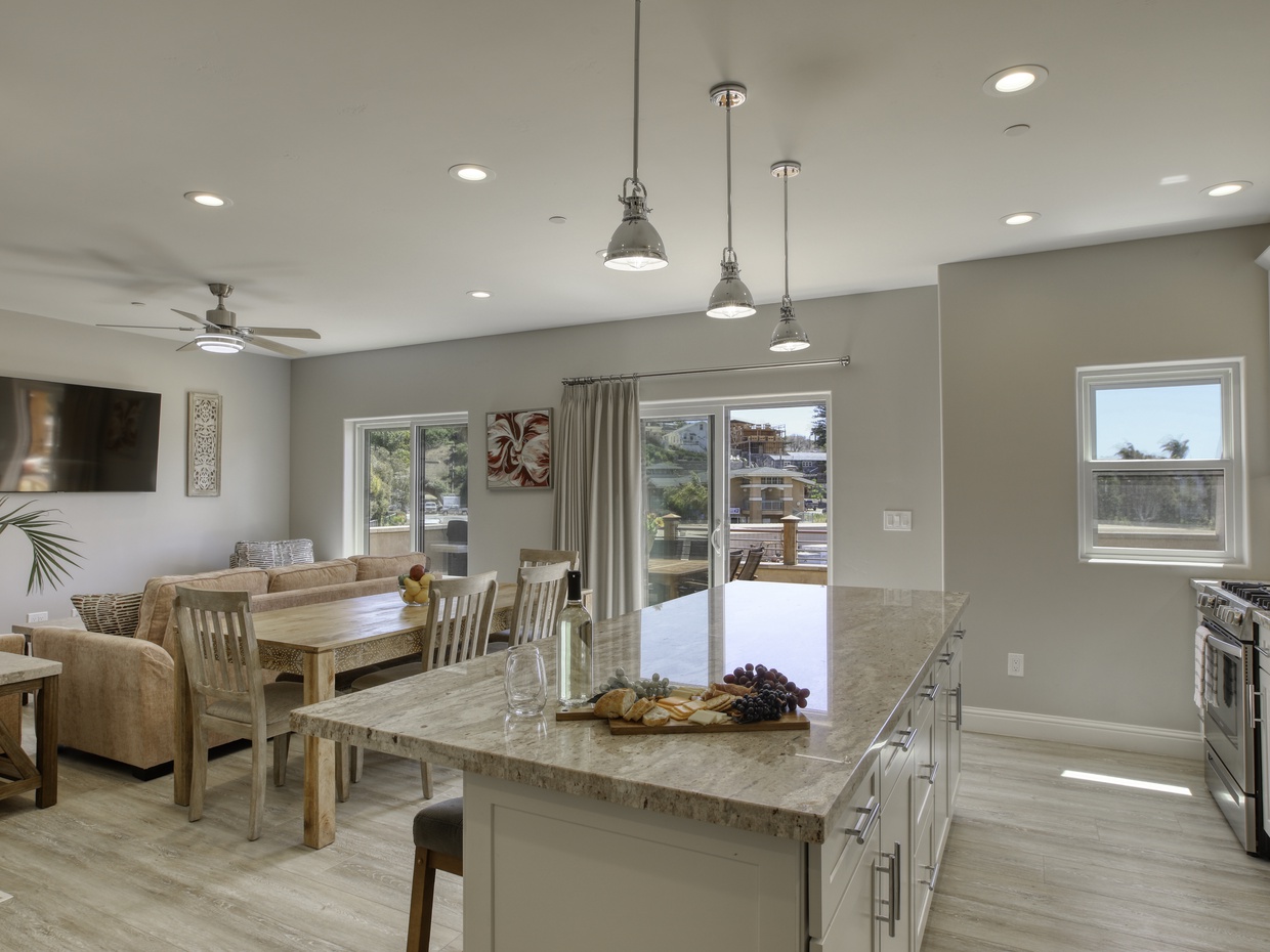 The roomy kitchen and dining area creates an enchanting atmosphere. Accommodating dining for six guests, with additional barstools available at the counter. Alternatively, enjoy outdoor al fresco dining on the patio just steps away.