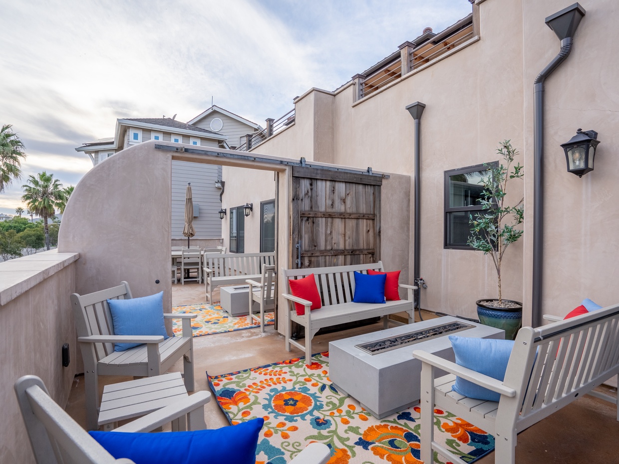 Overlooking the distant ocean, the private patio boasts a natural gas fire table, perfect for evening gatherings and warmth on cooler nights. 

Sneak a peak of the sliding door that opens to the neighboring four bedroom home. The lock-off door is opened when reserving both sides of the twin homes. 