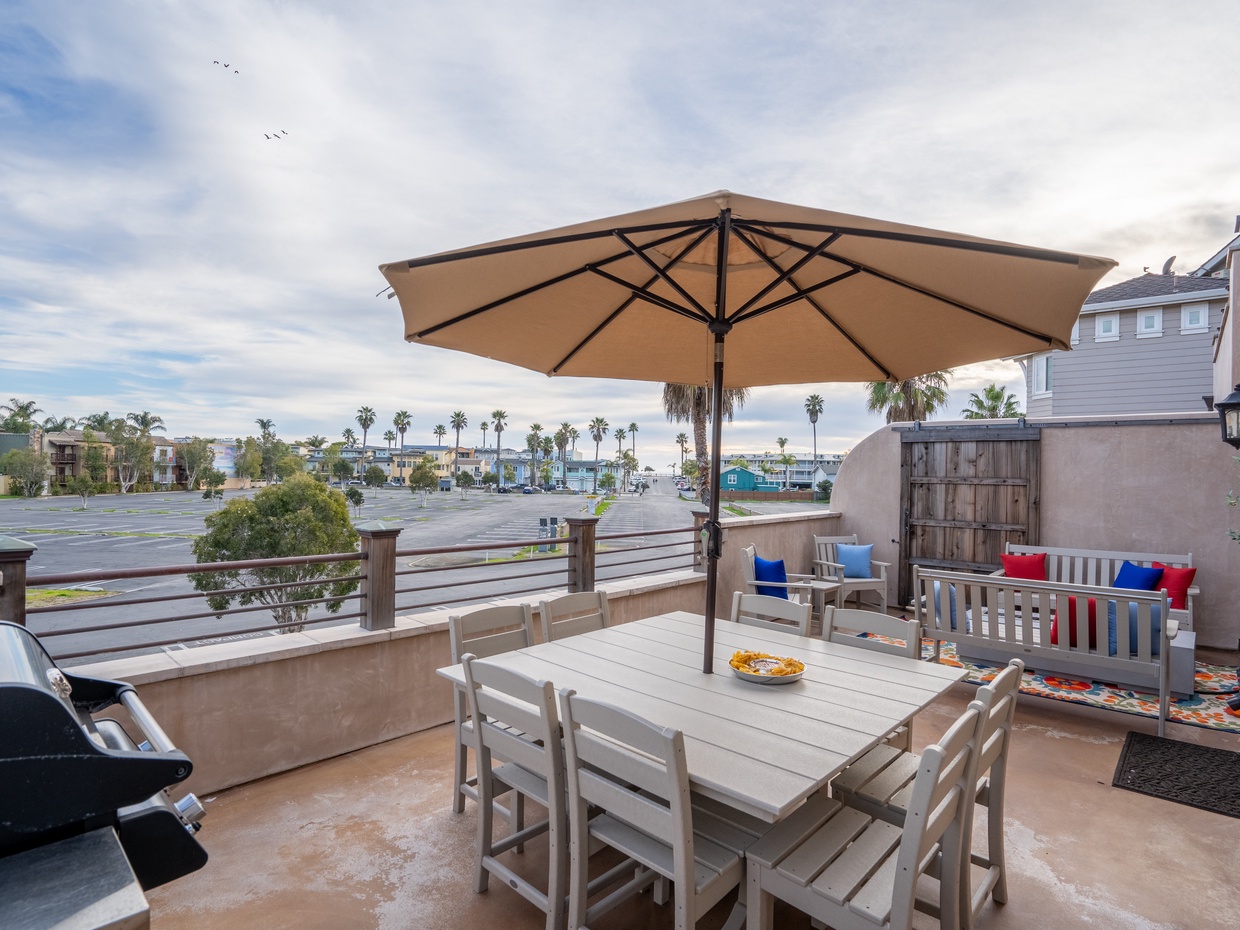 Equipped with a barbecue grill, ample seating, and a dining table, it provides an ideal setting for al fresco dining and relaxation with scenic ocean views in the background. Outdoor living is steps from the kitchen area. 