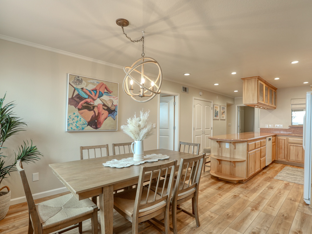 A spacious kitchen with dining for six and four additional bar stools at the counter.




