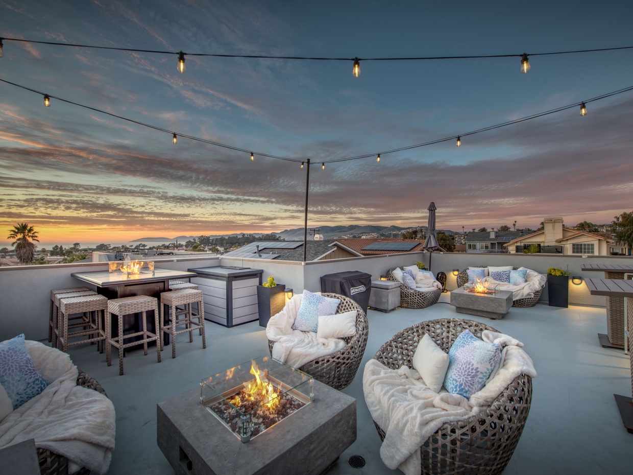 Multiple fire fixtures illuminate the roof deck create an elegant ambiance. Outdoor furniture extend living space.