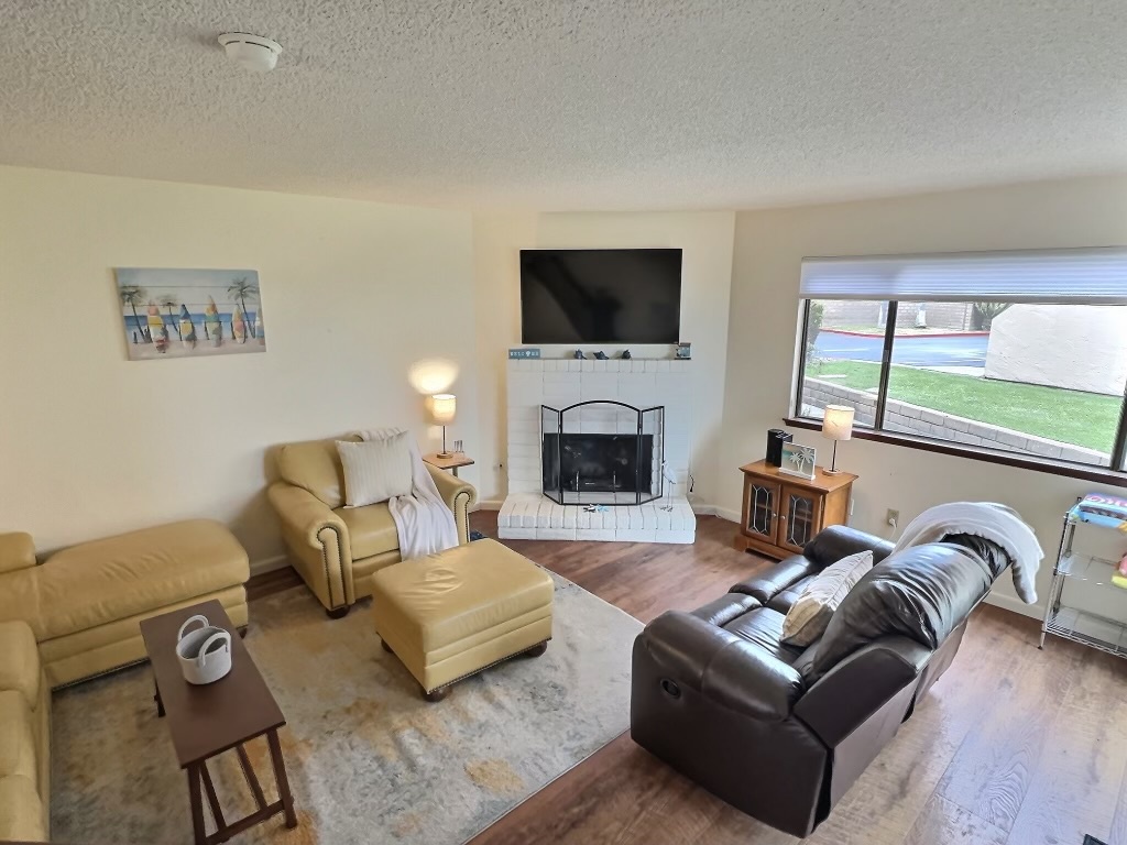 The living area includes a sleeper sofa with a full-size mattress and several comfortable chairs, perfect for family and friends to gather around the working gas fireplace and TV.