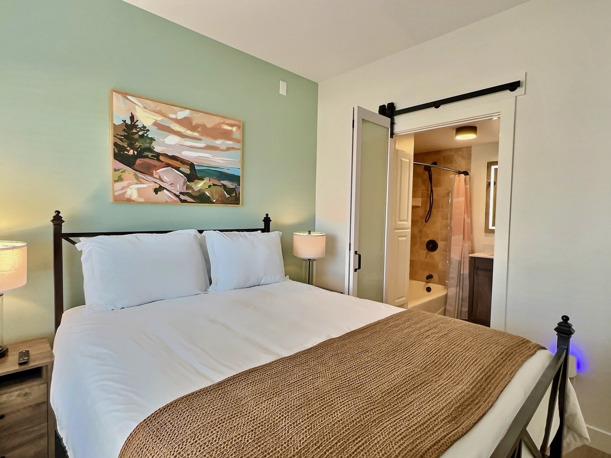 The master ensuite is filled with natural light and offers charming street views. It features a cozy queen bed with soft white linens, a SmartTV for entertainment, and plenty of closet storage for your convenience.



