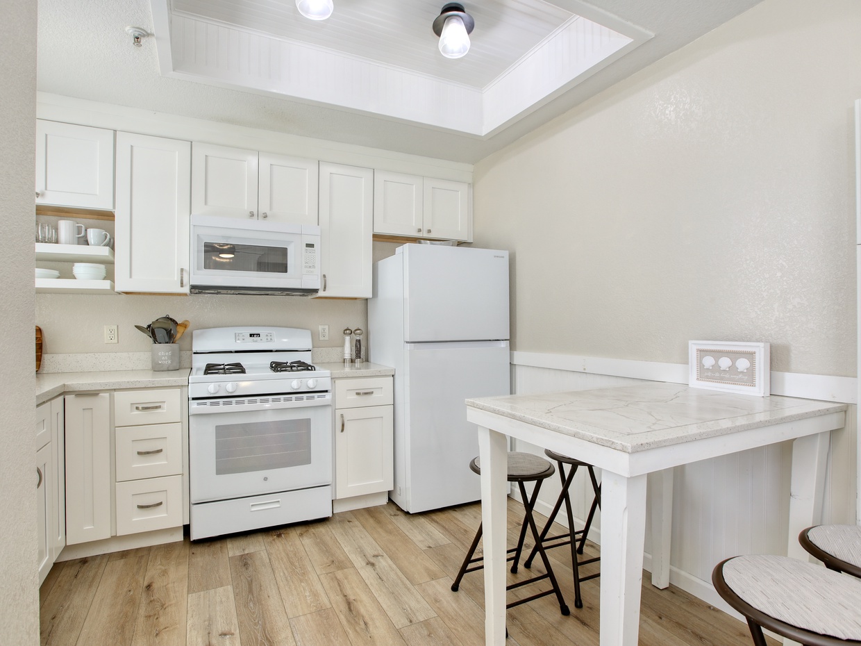 The fully equipped kitchen awaits your culinary creations, perfect for preparing delicious meals after a sun-soaked day at the beach.