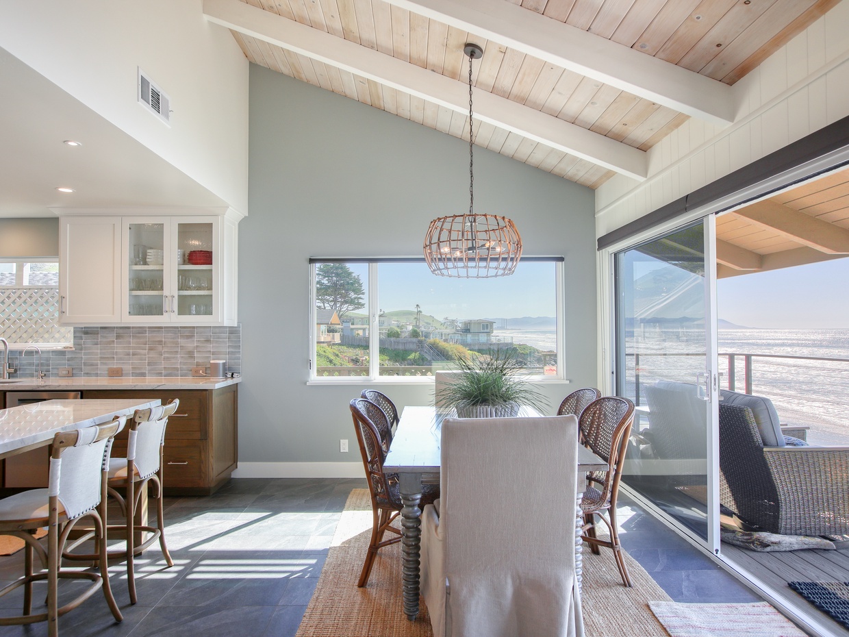 Savor panoramic Pacific views from the open-concept kitchen and dining area. Vaulted ceilings and expansive windows bring the coastline inside, creating the ultimate backdrop for every meal.