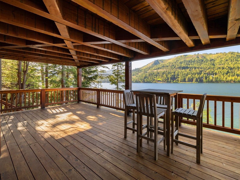 Covered deck with bar table off the primary suite and king bedroom