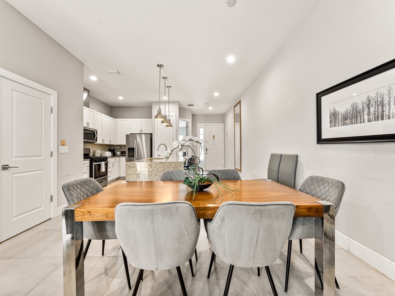 The dining area features a stylish table with seating for six, perfect for family meals or gathering with friends.