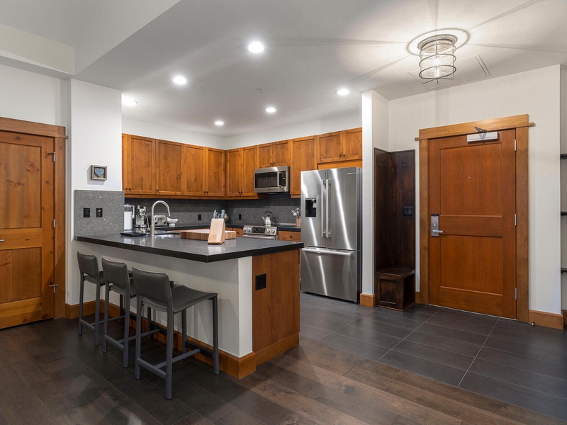 The bright kitchen offers plenty of prep space and a breakfast bar for three