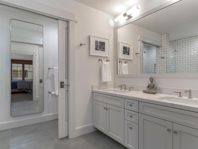 Primary ensuite with double sink vanity and full length mirror