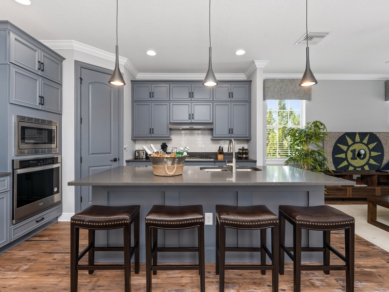 The kitchen island comes with 4 barstools and warm pendant lightning.
