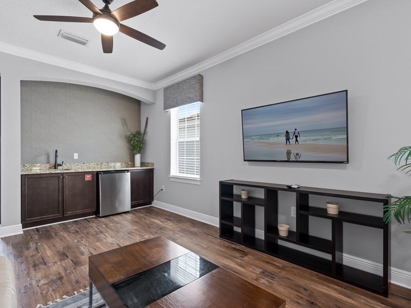 Cozy second-floor living room with TV and mini bar fridge.