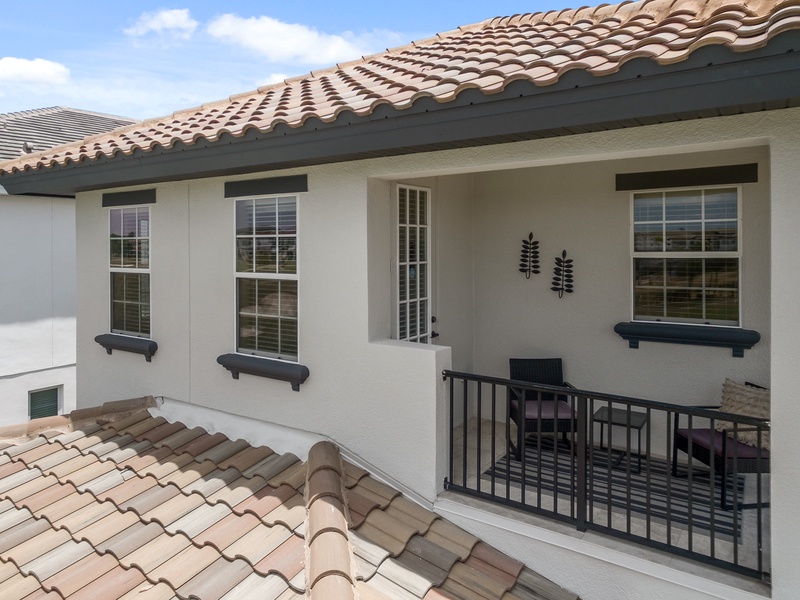 The master bedroom's balcony features two armchairs and a small table, creating a perfect nook for morning coffee.