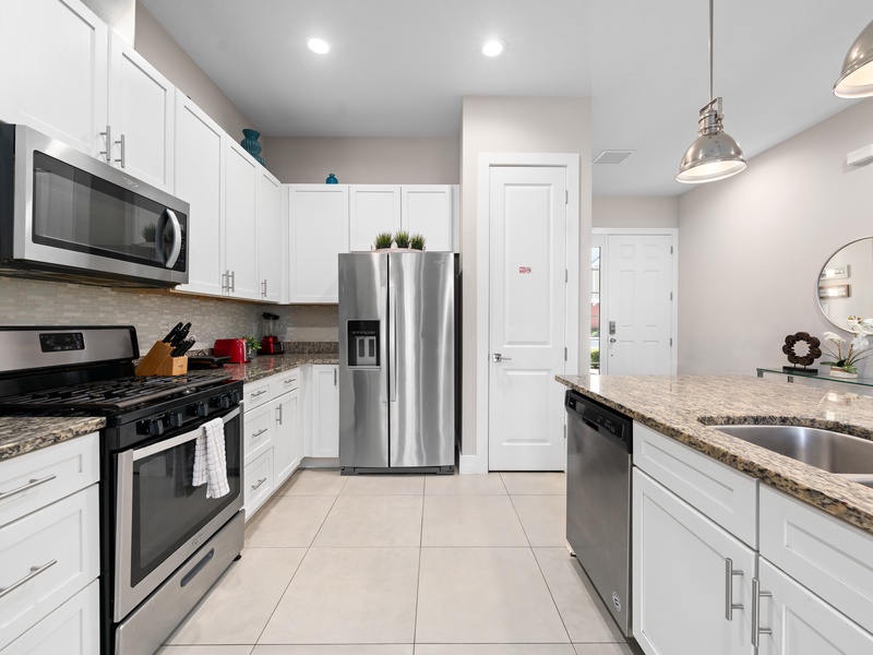 Cook with ease in a kitchen featuring stainless steel appliances and all essentials.