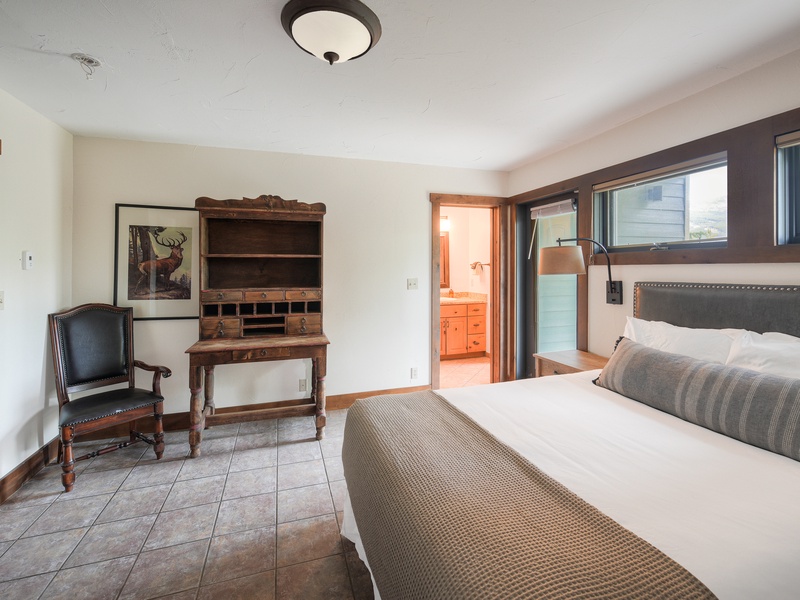 Fifth Bedroom (Level 1): King Bed with writing desk and armoire with a TV inside.