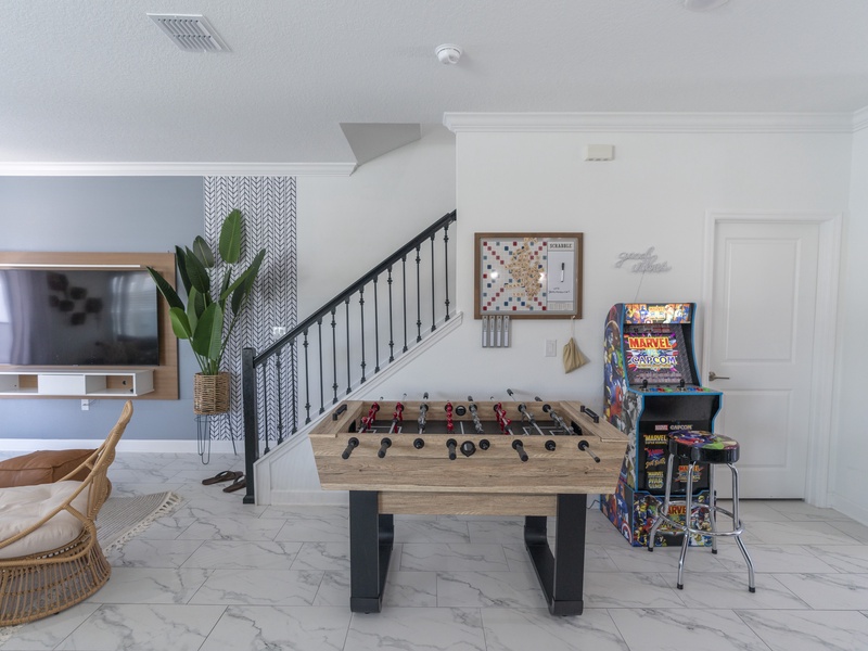 Enjoy endless entertainment in this corner with an arcade game and a foosball table, perfect for fun-filled moments!
