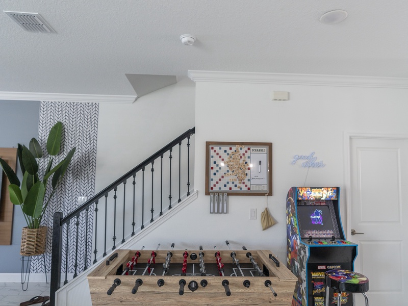 Enjoy endless entertainment in this corner with an arcade game and a foosball table, perfect for fun-filled moments!