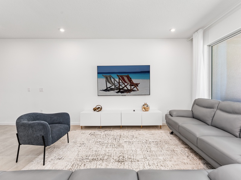 Enjoy a movie night in our cozy living room, complete with a large-screen TV and comfortable plush seating.