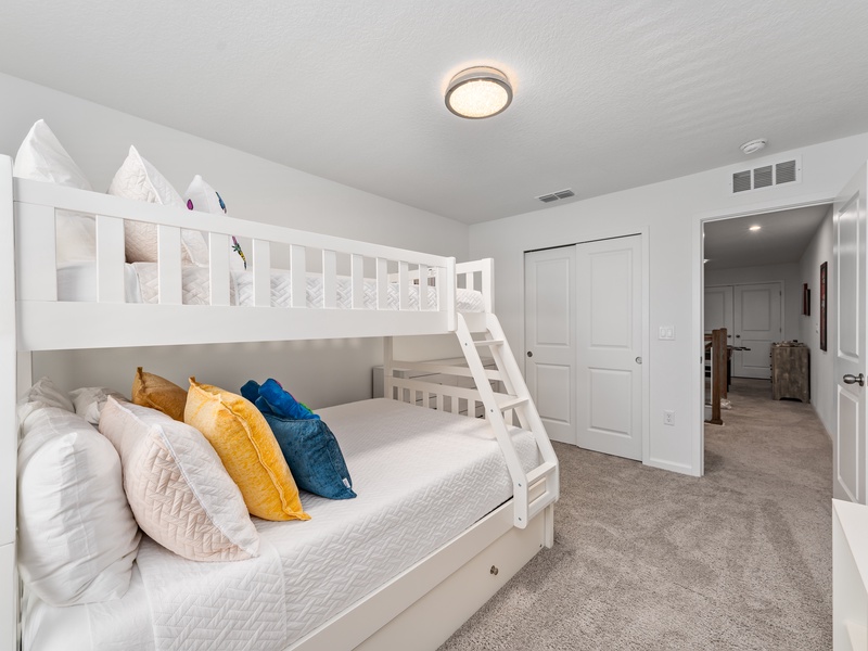 A fun and cozy room for the kids, featuring a bunk bed with a full-size bed on the bottom, a twin on top, and a pull-out mattress underneath.