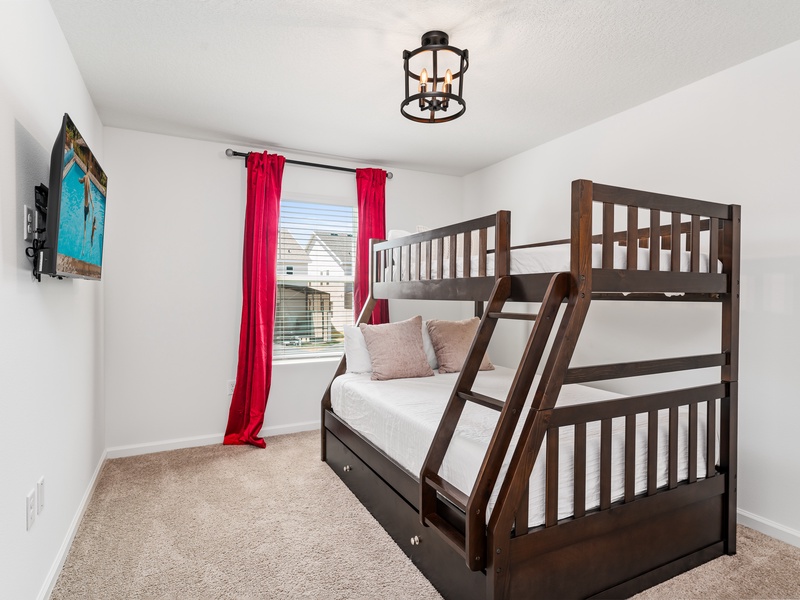 A fun and cozy room for the kids, featuring a bunk bed with a full-size bed on the bottom, a twin on top, and a pull-out mattress underneath.