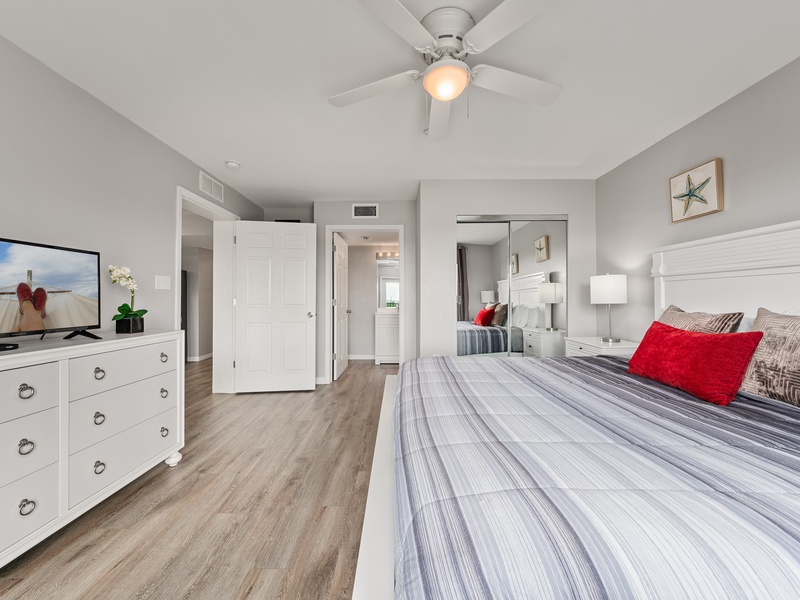 The master bedroom offers balcony access, a private bathroom, TV, and closet space.