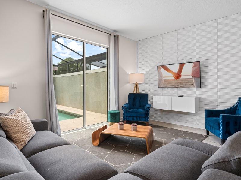 Enjoy cozy movie nights in our living room, featuring ample plush seating,  TV, and a warm, inviting atmosphere.