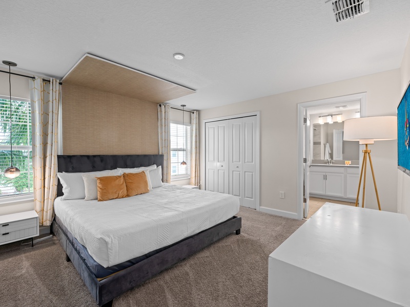 The master bedroom features a private en-suite bathroom, spacious closet, and its own TV for added comfort and convenience.