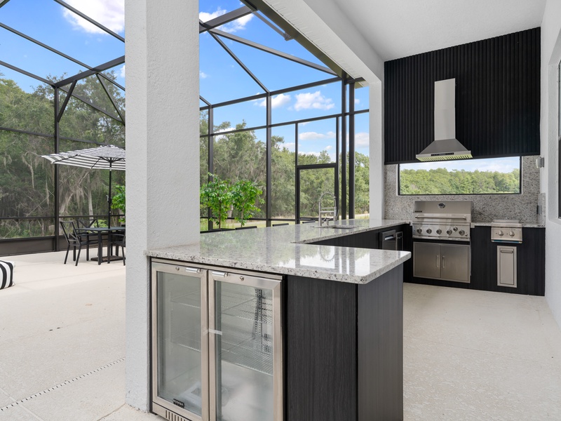 Enjoy cooking in our fully-equipped outdoor kitchen, complete with a grill, sink, and bar seating.
