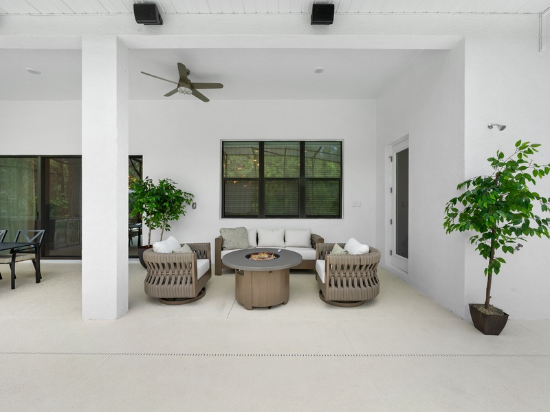 Relax in our charming outdoor living nook, featuring plush seating and a cozy fire pit at the center.