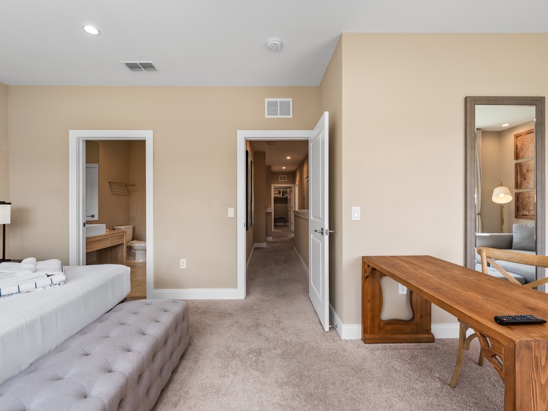 Our master bedroom features a seating area, TV, ensuite bathroom, ample closet space, and a desk to comfortably work or study during your stay.