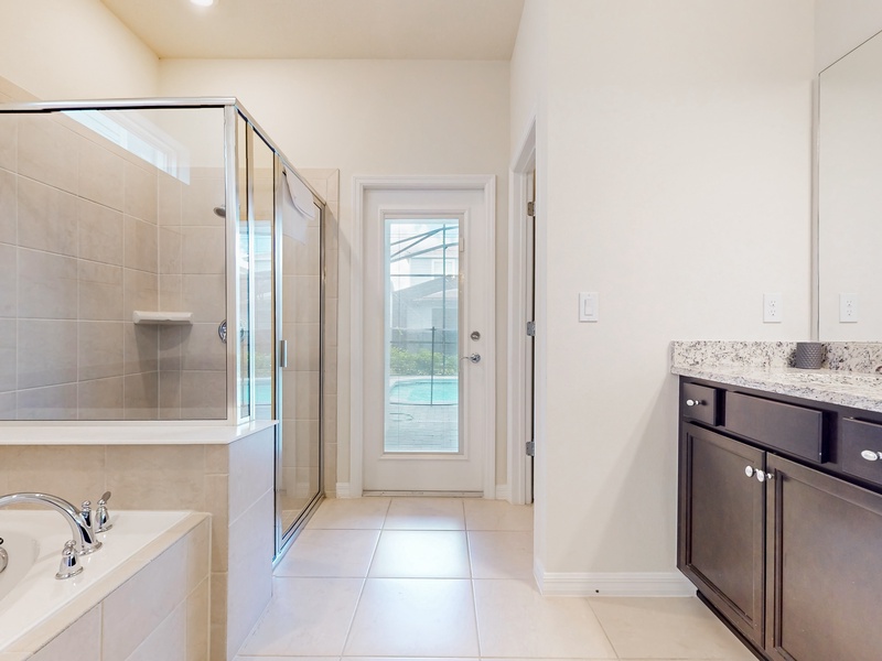 1st floor primary ensuite.  Soaking tub, walk in shower, toilet closet, 2 sinks & exterior access to lanai area.
