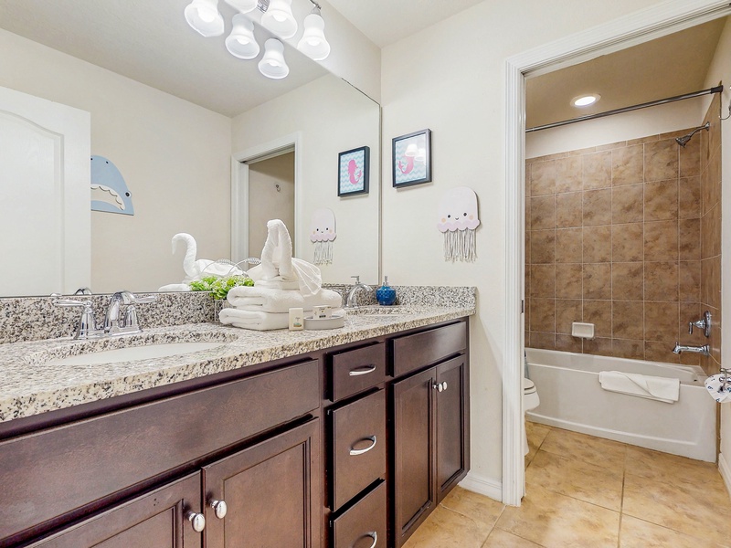 Shared bathroom between Bedroom #5 & Bedroom #6 with double vanity sink, toilet & shower/tub combo